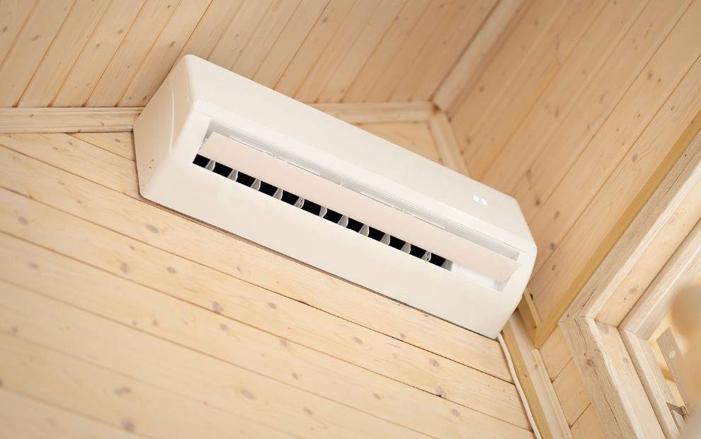 Un condizionatore a pompa di calore bianco affisso ad una parete in legno