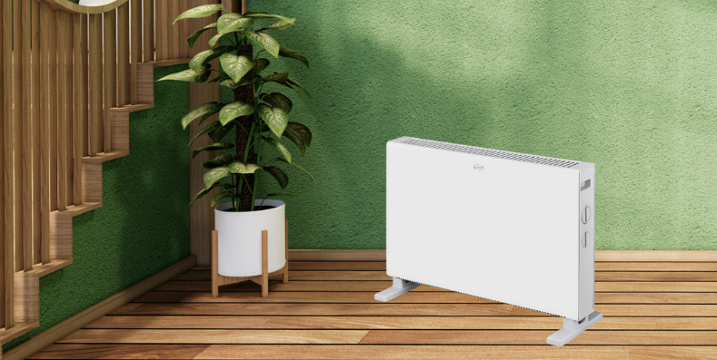 Un termoconvettore bianco nella stanza di una casa, sopra a un pavimento in legno.